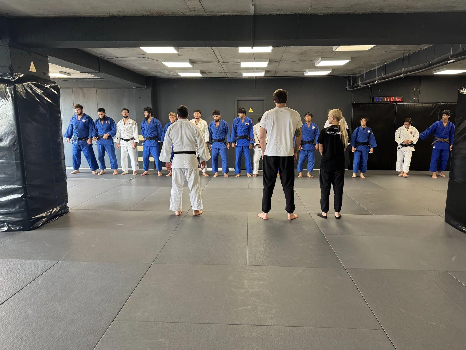 Archive photo of a judo group in blue and white judogi lined up on the mat
